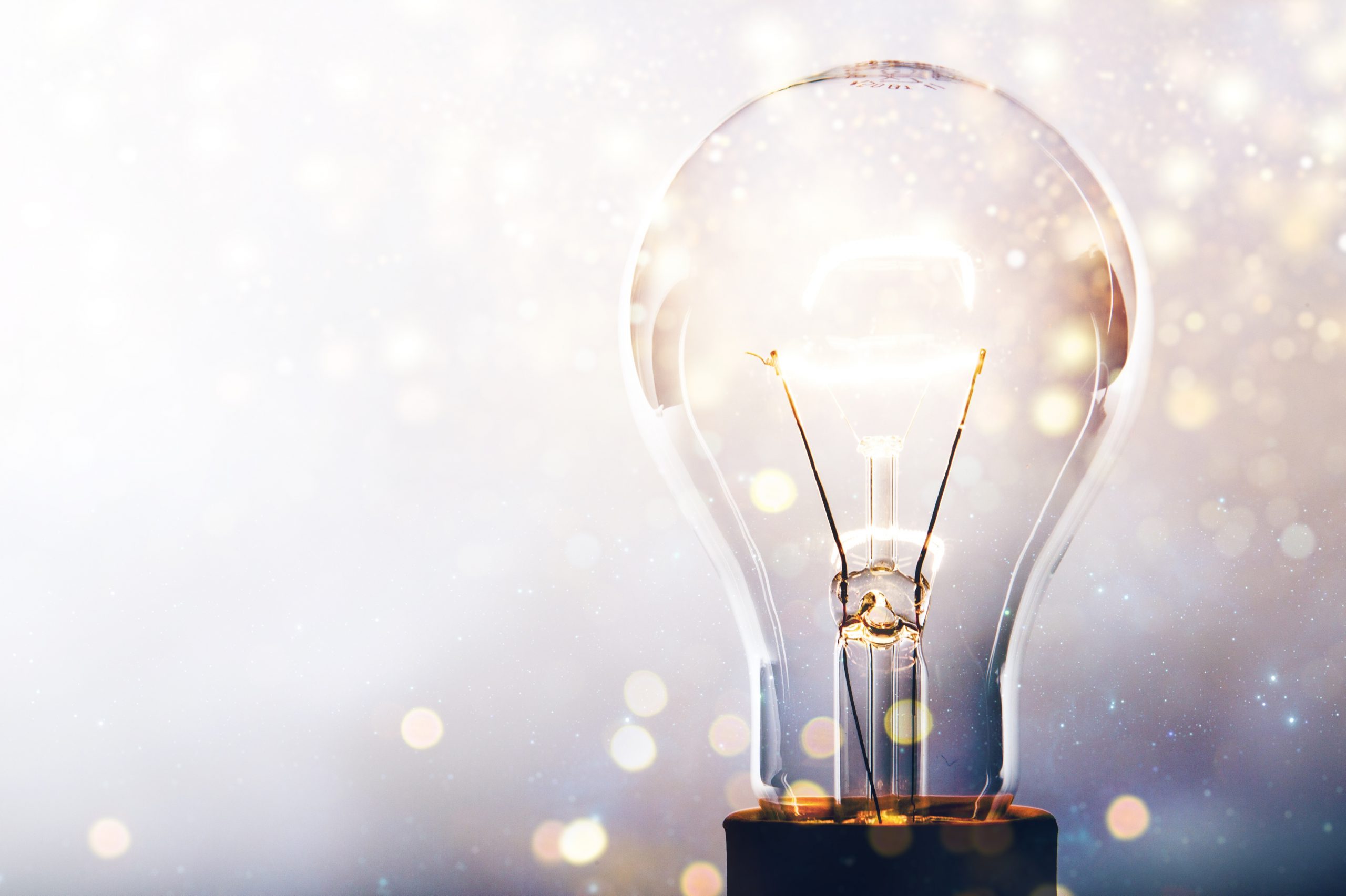 Glowing glass light bulb on background